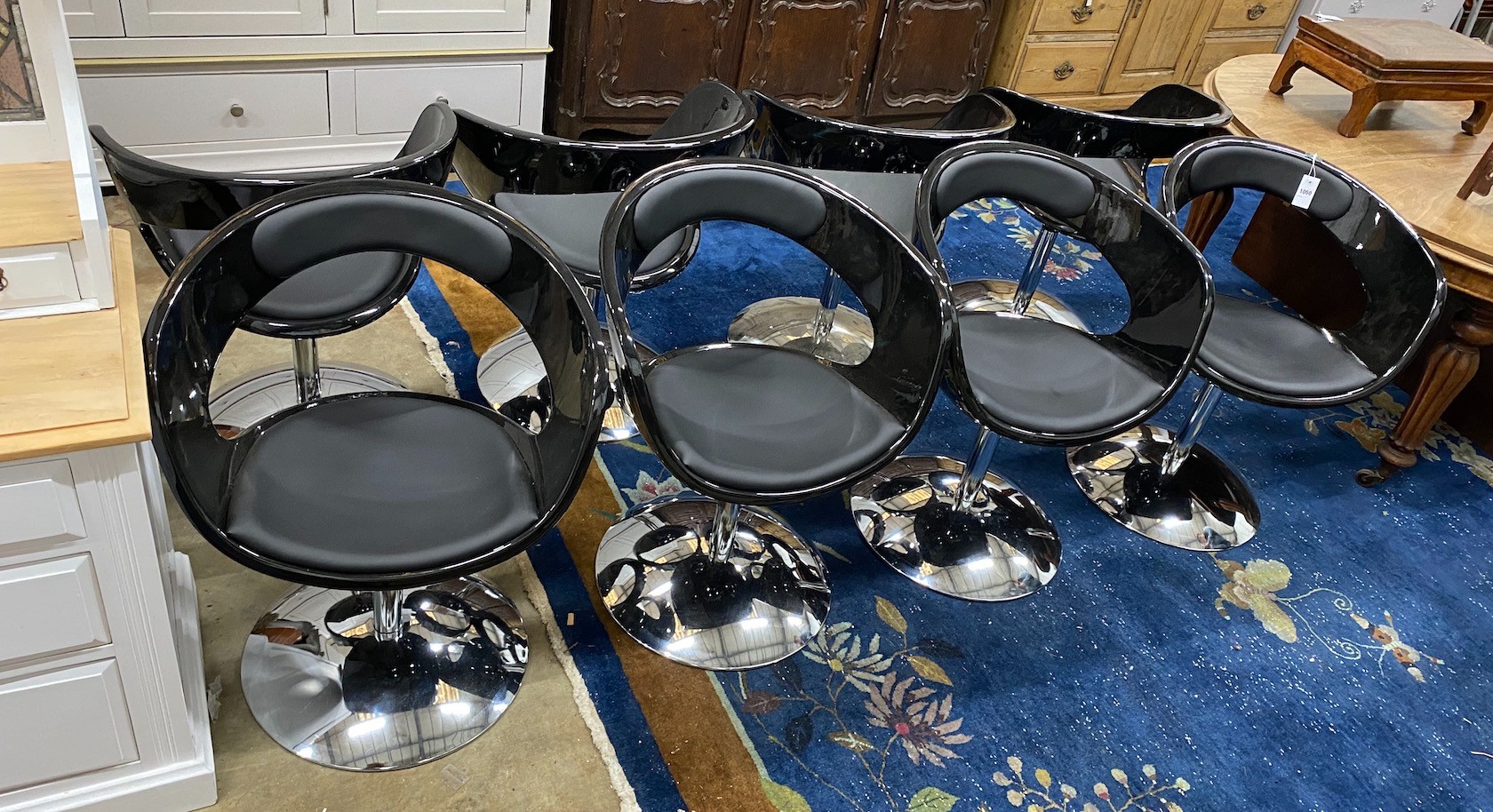 A set of eight black phenolic dining chairs with telescopic bases, width 63cm